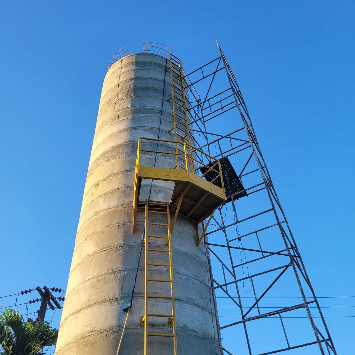 Reservatório elevado de concreto com escada e plataforma amarelas