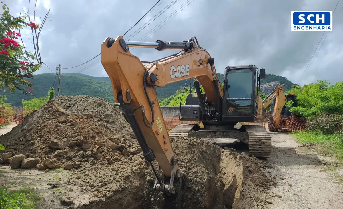 Escavadeira abrindo vala em obra de saneamento